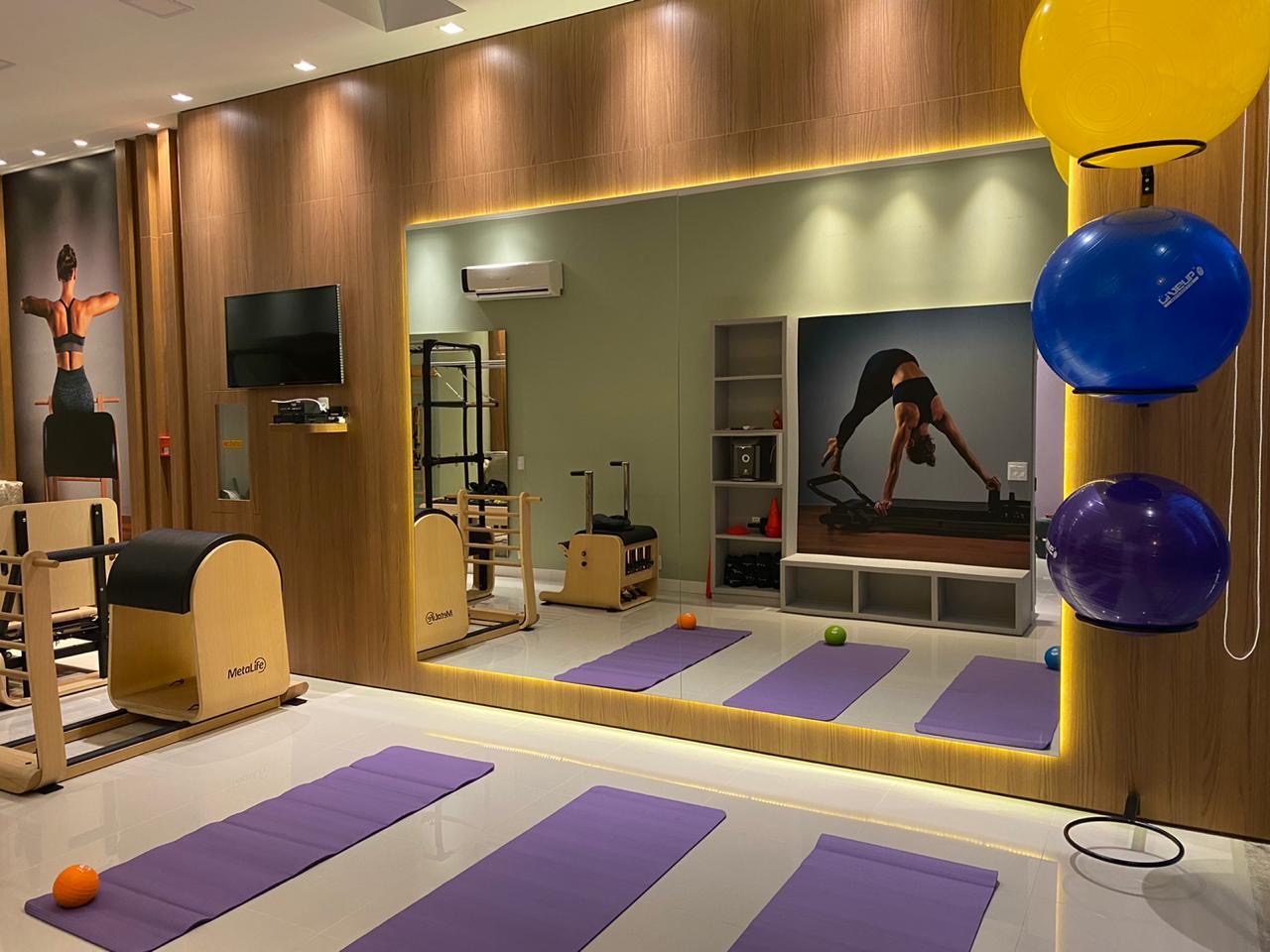 Interior do Studio Volari — sala de Pilates com mats, aparelhos e bolas